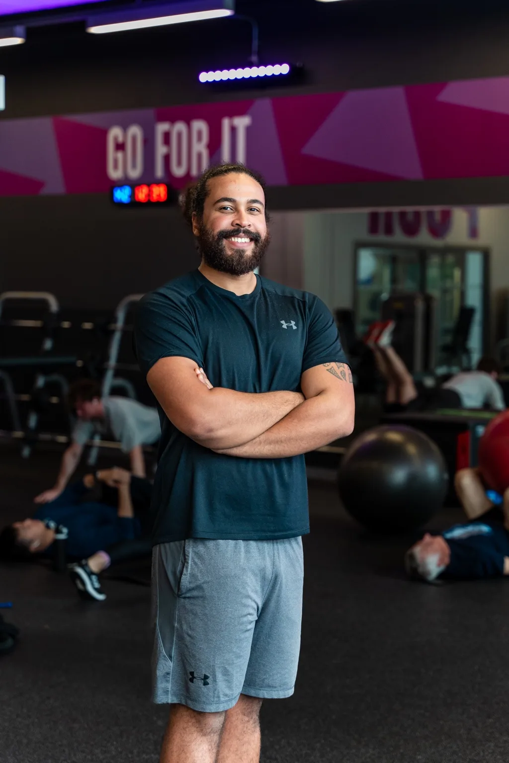 CJ White standing with his arms crossed in a gym