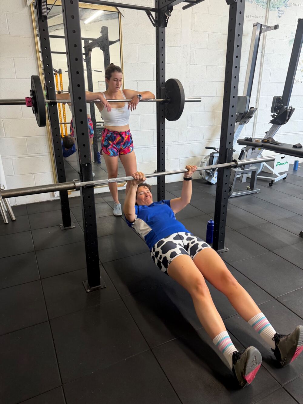 CJ coaching a client through an inverted row in the Greenwich studio